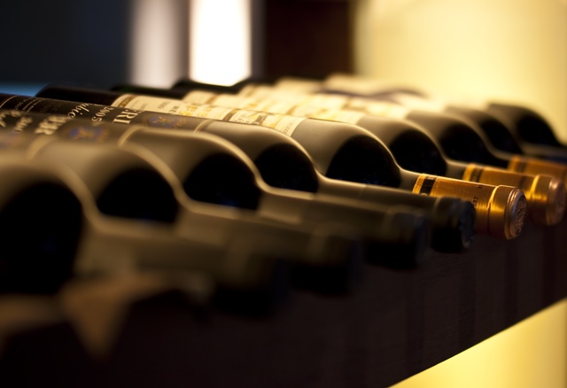 bouteilles de vins alignées sur une étagère dans une cave